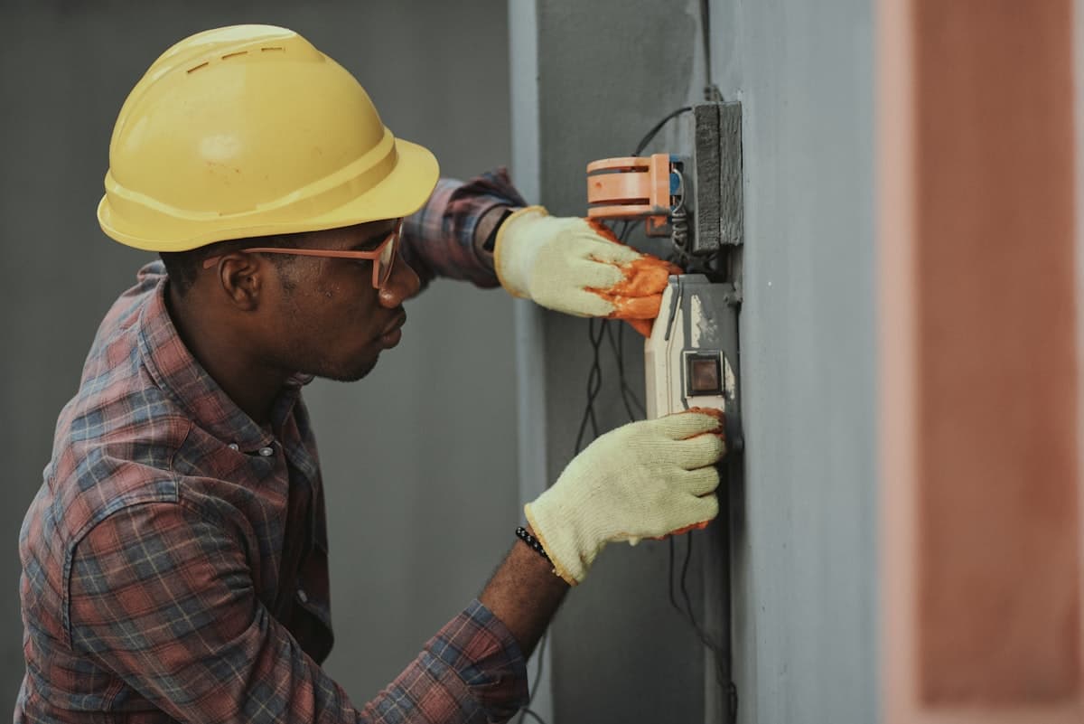 Utility electrician working on a wall-mounted electrical box